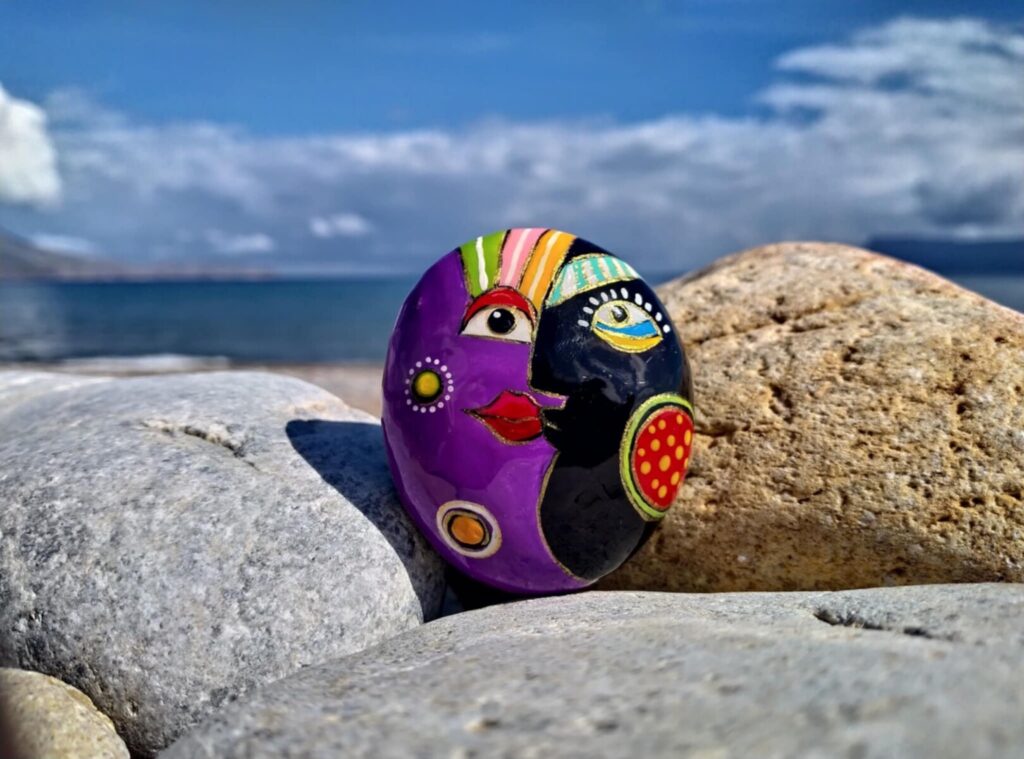 Abstravt face painted on rock placed on sea stones in Kissamos gulf