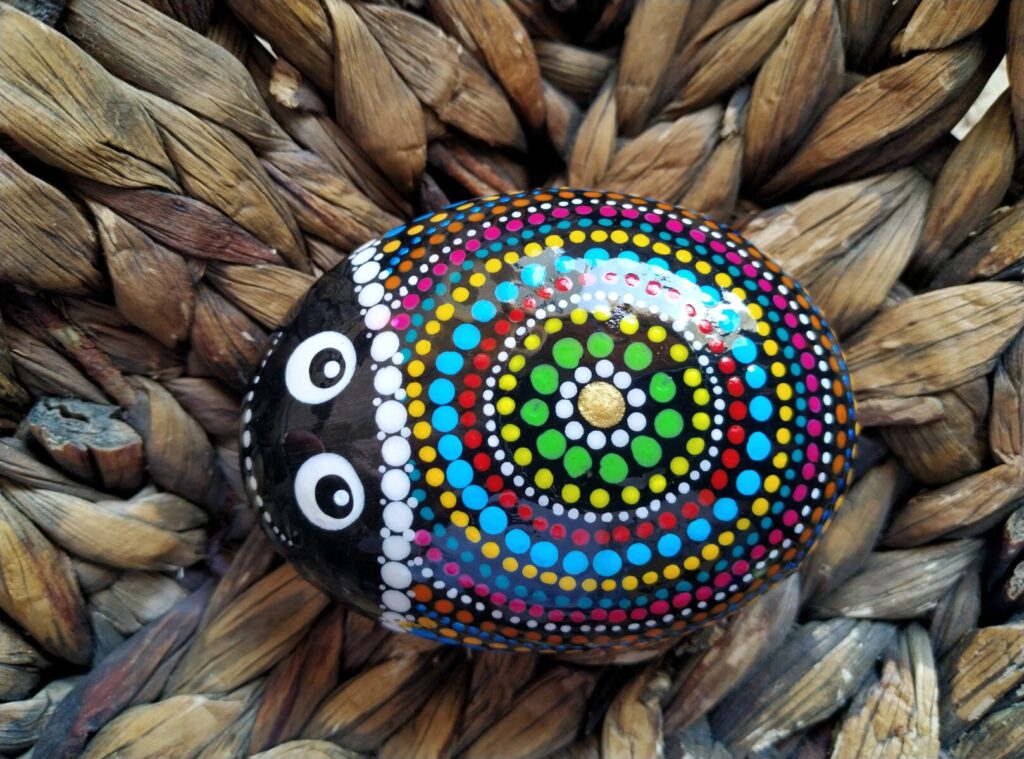 Ladybag painted on stone inside a basket