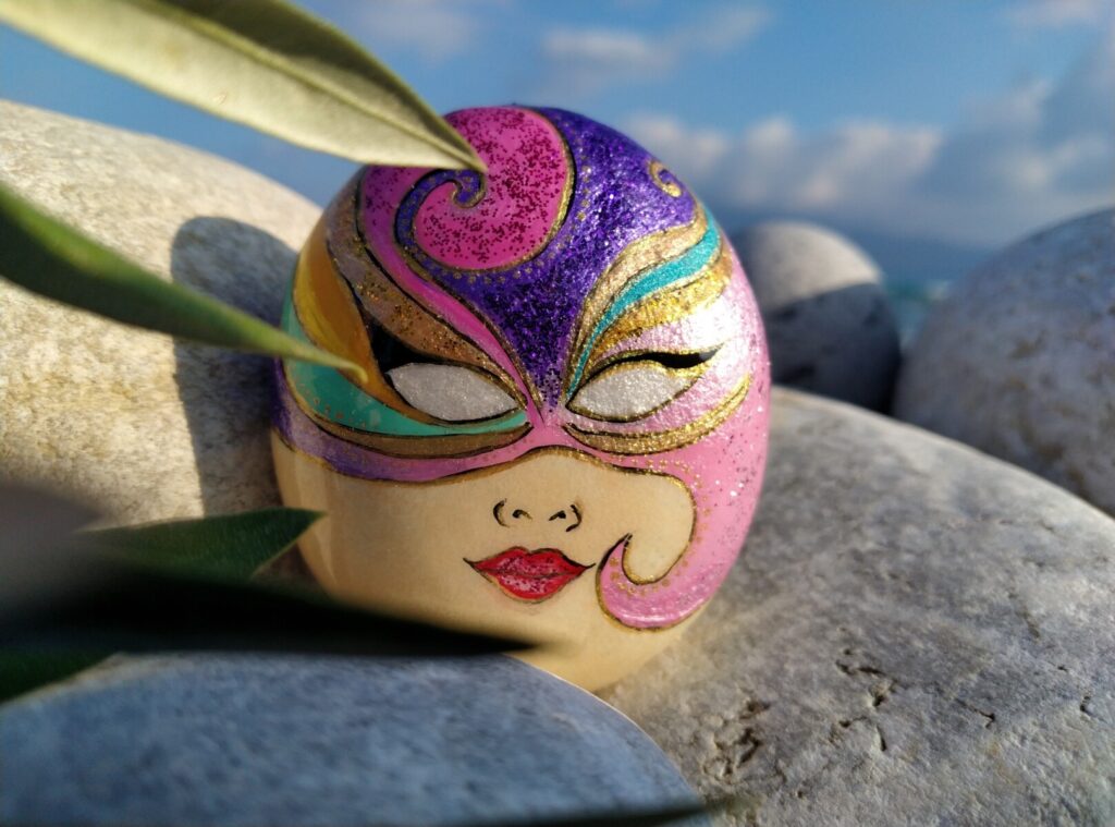 Sea stone with venetian mask painted on it