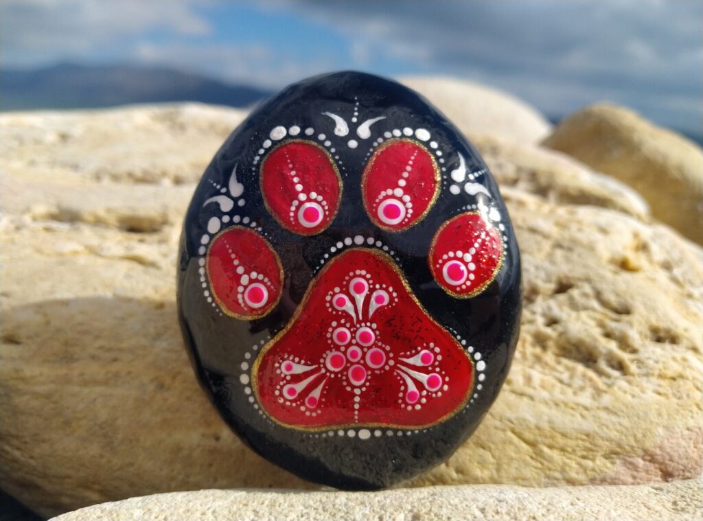 Unique painted stone with little paw on it