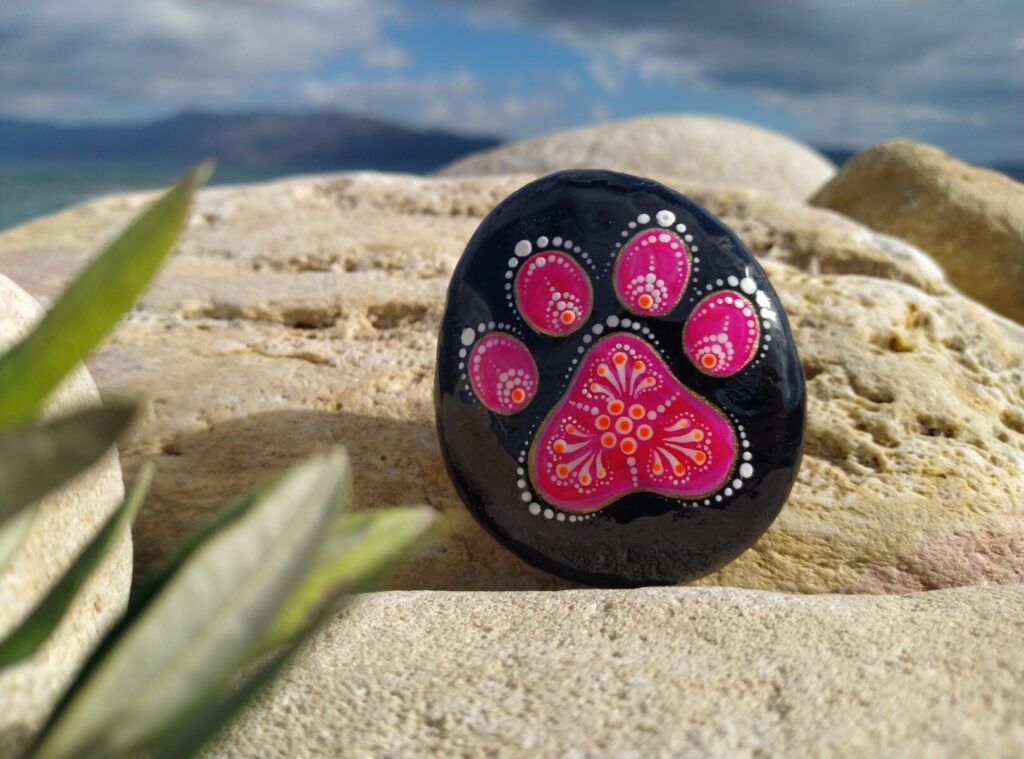 Little pink kitty paw painted on stone places near Kissamos beach