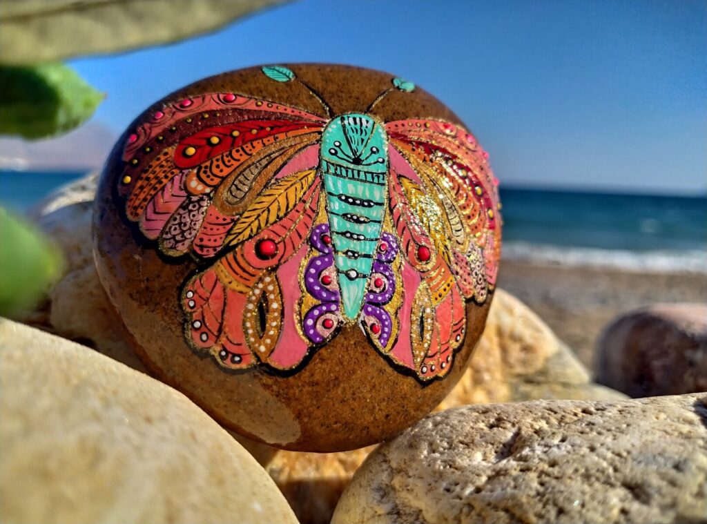 colorful moth painted on sea stone