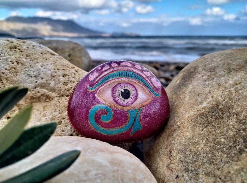 Evil eye painted on stone by the sea