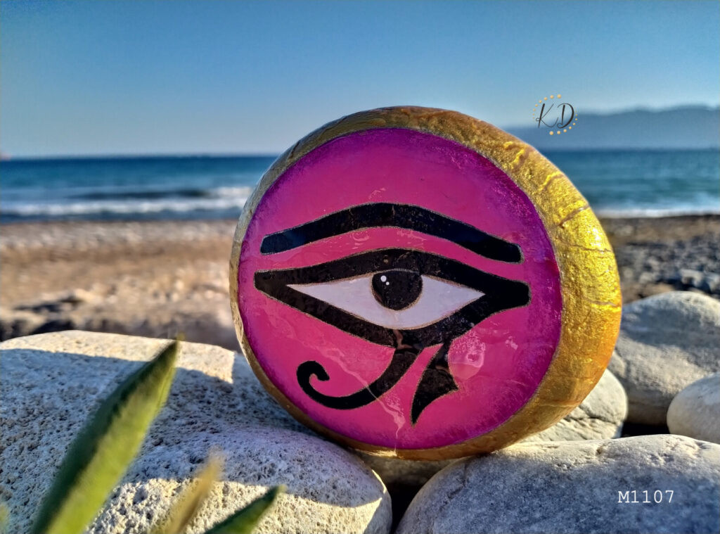 Vibrant pink eye painted on stone. The eye of Horus